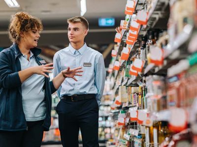 Store manager training young worker. Supermarket manager giving training to a trainee.